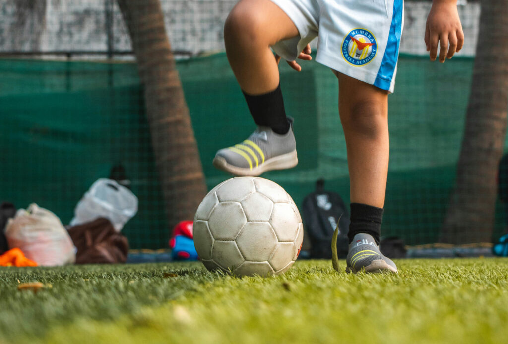 Toddler with one foot on a football
